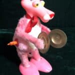 A windup Pink Panther bangs a pair of cymbals.