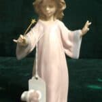 A Lladro figurine depicts a girl waving a magic wand over a dog.