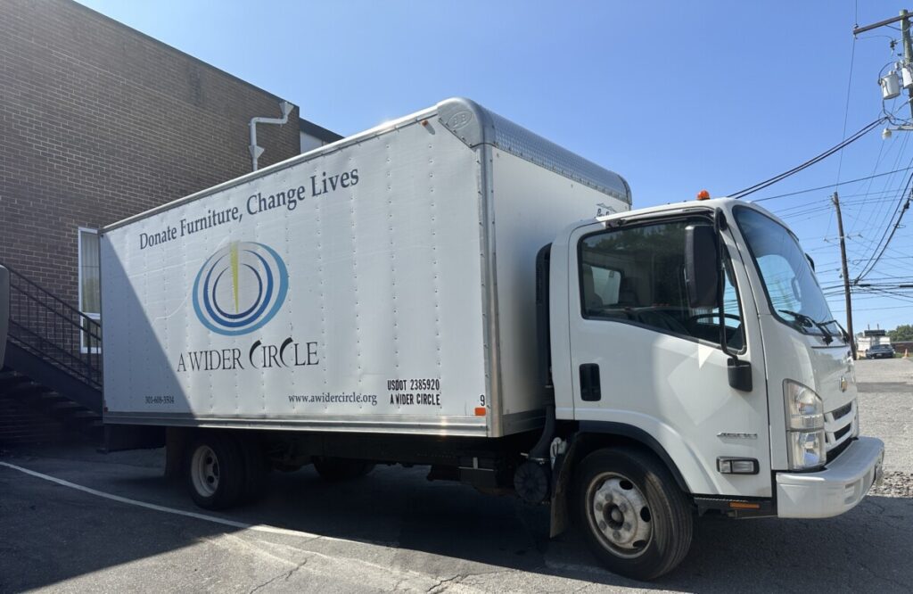 A white A Wider Circle box truck is poised for the next call from people with furniture to donate.