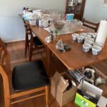 A teak Mid-century modern dining table with matching chairs. The chairs have black seats.