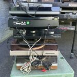 A stack of record players sits on a moving cart.