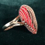 A gold-banded ring with heart-shaped stone.