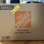 A brown cardboard box with yellow sticker marked for donations.