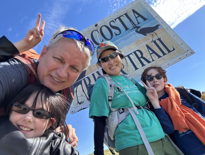 My wife and I pose for a picture in front of an Anacostia River sign.