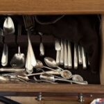 A drawer full of random sterling silver flatware sits unused.