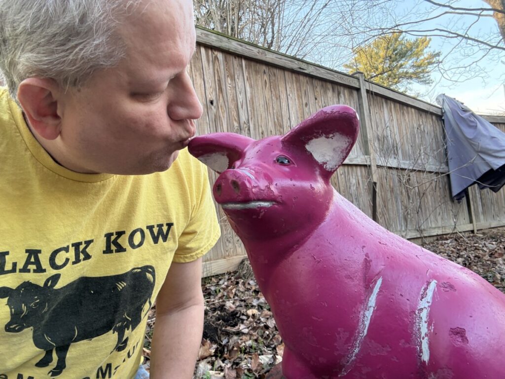 Chris Lancette kissing restored cement pig during estate liquidation and home cleanout project in Maryland