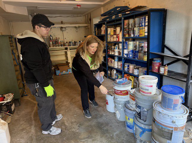 Raea Leinster inspecting paint and chemicals during household hazardous waste removal in Montgomery County