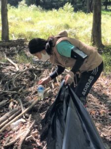 Won-ok Kim picking up trash near Sligo Creek in Montgomery County to prevent litter from entering the Chesapeake Bay watershed.