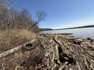 A car tire, plastic bottles and other pollution line the Potomac River shore at Piscataway Park.