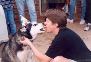 Author Chris Lancette in much younger years feeding Orion (wearing party hat) birthday cake -- before he learned that was not wise.
